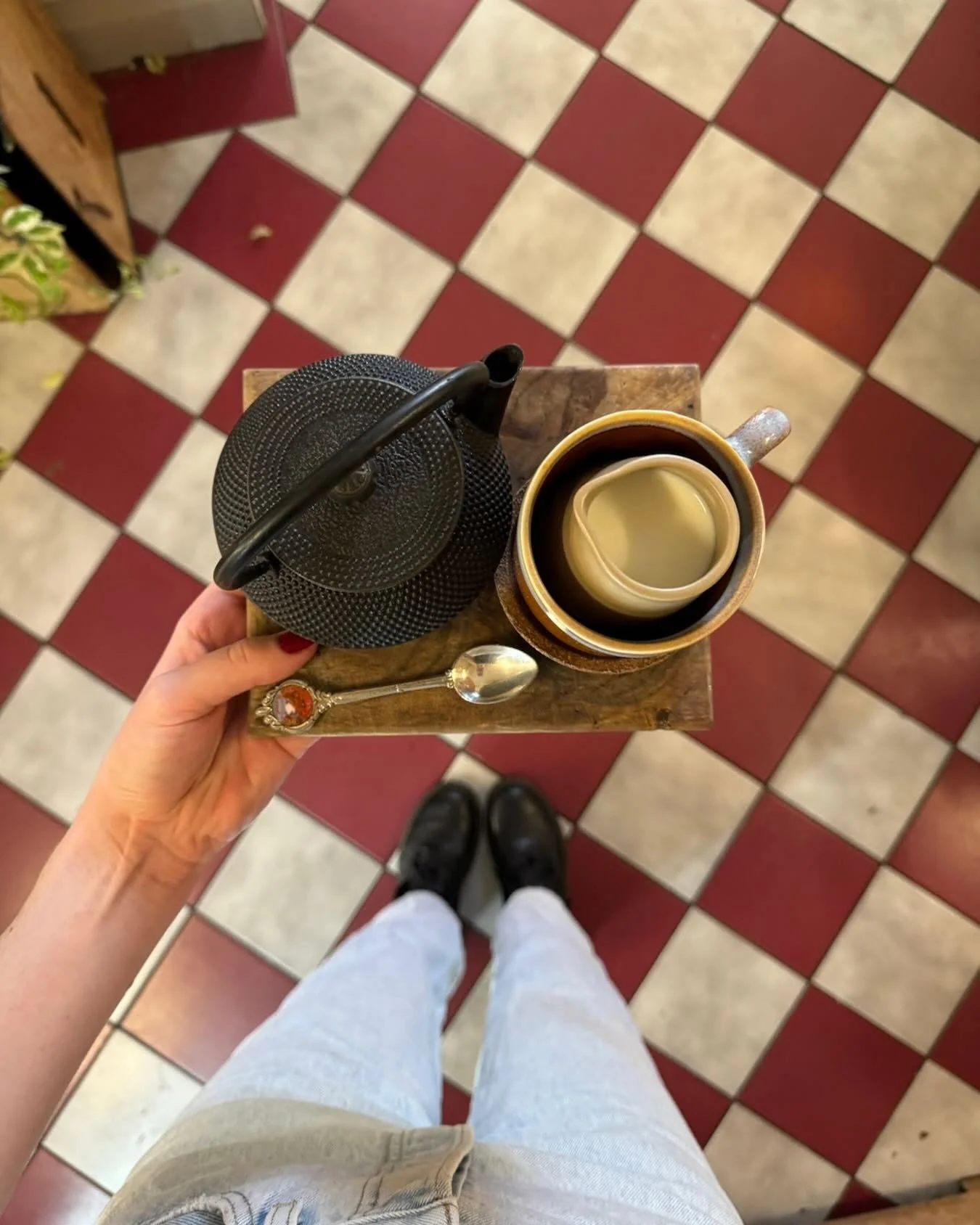 A pot of Mayde tea on the checkerboard tiles
